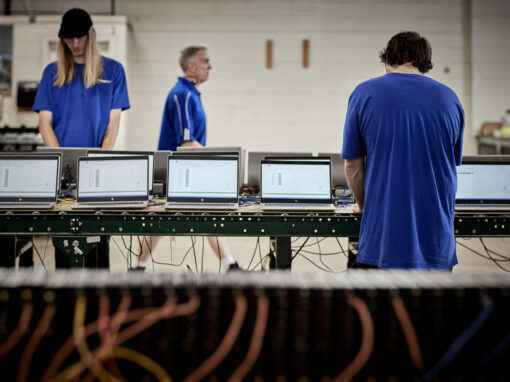 OceanTech technicians monitoring automated diagnostic testing software on rows of laptops during a bulk ITAM audit