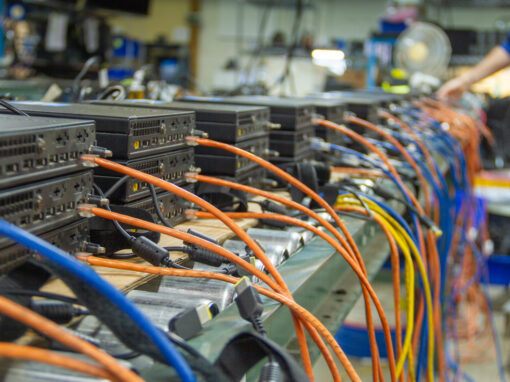 Rows of enterprise desktop computers wired to a centralized network bench for high-volume diagnostic auditing