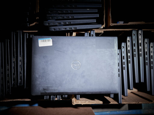 Stacks of decommissioned enterprise Dell laptops sorted in cardboard boxes for secure data sanitization and asset recovery